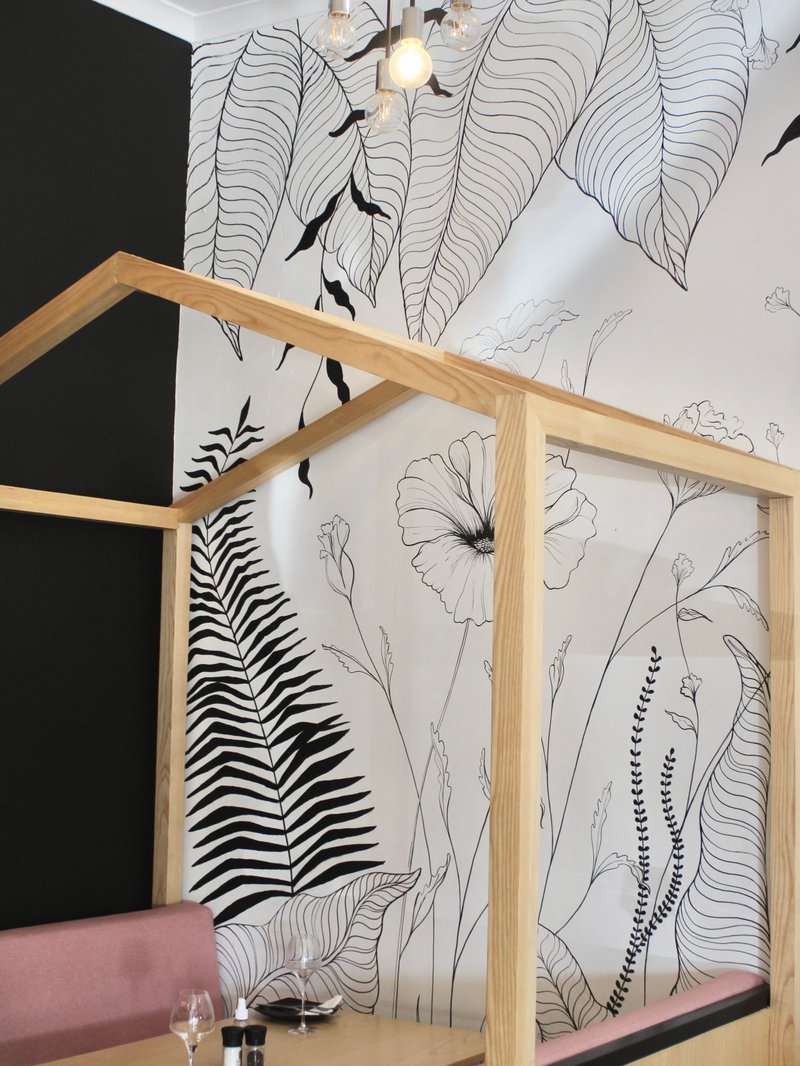 Full-height wall mural of oversized botanical line drawings in black on white